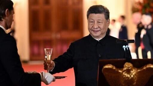 China's President Xi Jinping takes a glass to propose a toast during the State Dinner