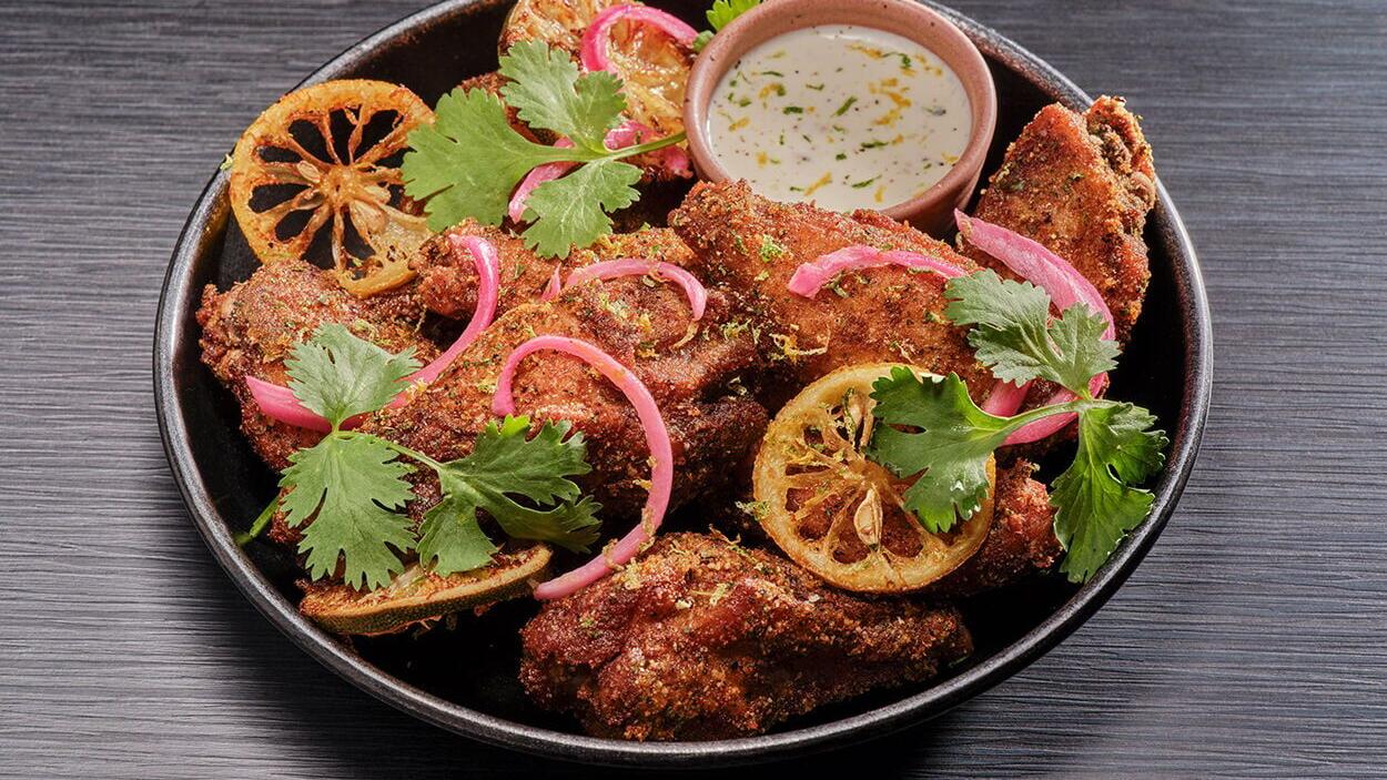The Lemon &amp; Lime Black Pepper Wings, served with pickled onions and fresh cilantro, bring the bold, tangy flavor to Hard Rock Rising's limited-time menu.