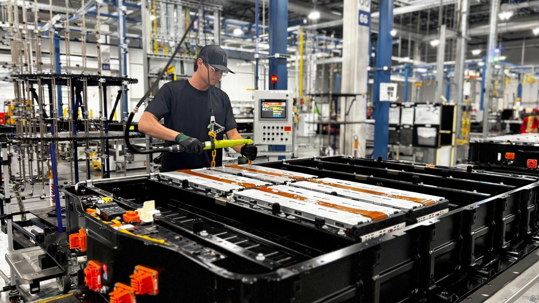 A GM team member installs battery modules with cells made with recycled battery materials into a new battery pack at Factory ZERO.