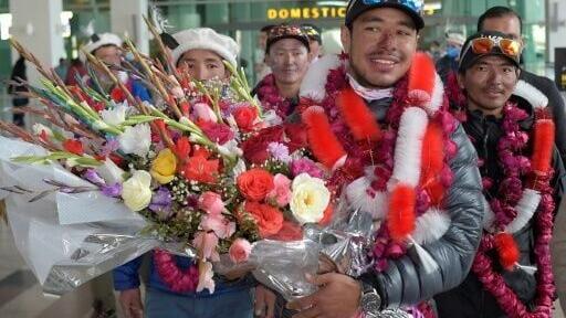 Nepal's climber Nirmal Purja (2R) walks upon his arrival along with his team at the airport after becoming the firsts to summit Pakistan's K2 mountain in winter, in Islamabad on January 21, 2021