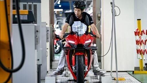 A worker tests a assembled motorcycle at the ZXMoto factory in Chongqing, southwestern China