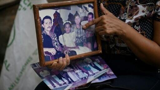 Marlene Nino points to an old photo of her sister Doris, who was killed when her building collapsed in the 7.4 magnitude earthquake in Cali, Colombia