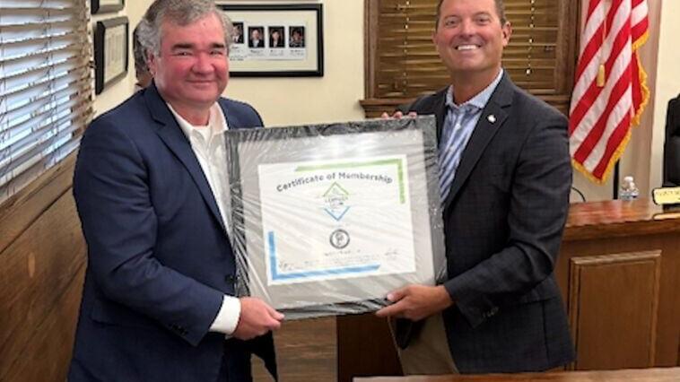 David Cole, President of the Ductile Iron Pipe Research Association (DIPRA), right, presents a certificate to Troy, AL, Mayor Jason A. Reeves during a City Council meeting, welcoming the city to the association’s Century Club, which honors the strength ...
