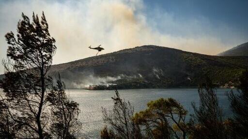 A firefighting helicopter battling a wildfire on the Greek island of Skyros
