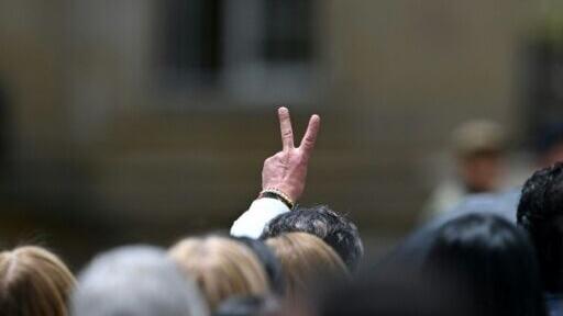 Former leader Gustavo Petro flashes the V sign as he leaves Colombia’s presidential palace for good