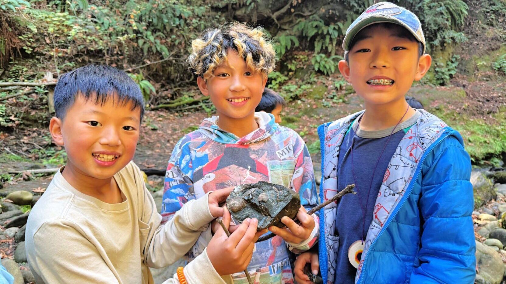 Students smiling while holding a fossil.