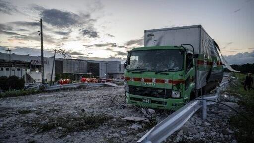 A damaged truck is seen on a debris-covered road in Japan's Kashima after a powerful earthquake