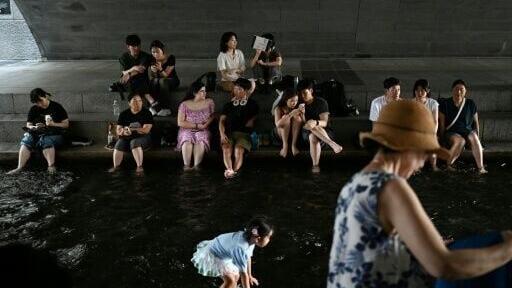 People cool off under a bridge over the Cheonggyecheon Stream in Seoul