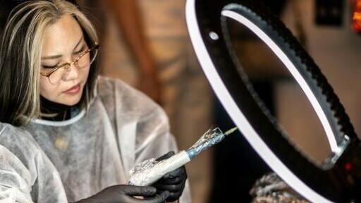 A scalp tattoo artist conducting a demonstration during a contest in Naha, Okinawa Prefecture