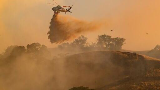 A helicopter drops water on Little Fire in Pleasanton, California on July 21, 2026