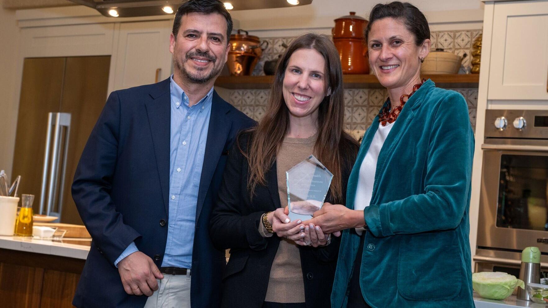 Kristen Rasmussen presents founding exhibitor recognition to Danone USA nutrition and scientific affairs leaders Miguel Freitas and Amanda Blechman at the inaugural Food is Life, Food is Health Summit.