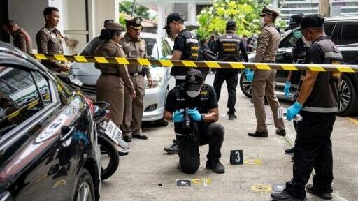 Police officers gather evidence at the scene of the shooting