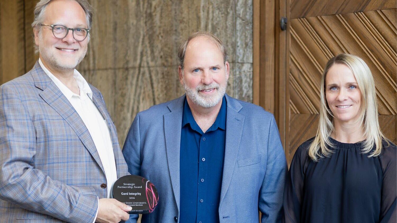 Senior Partner Doug Hindsley (left) and Forensic Principal Amanda Todhunter (right) of Card Integrity accept the 2026 Strategic Partnership award from Cory Harms, Chief Procurement Officer at Iowa State University (center).