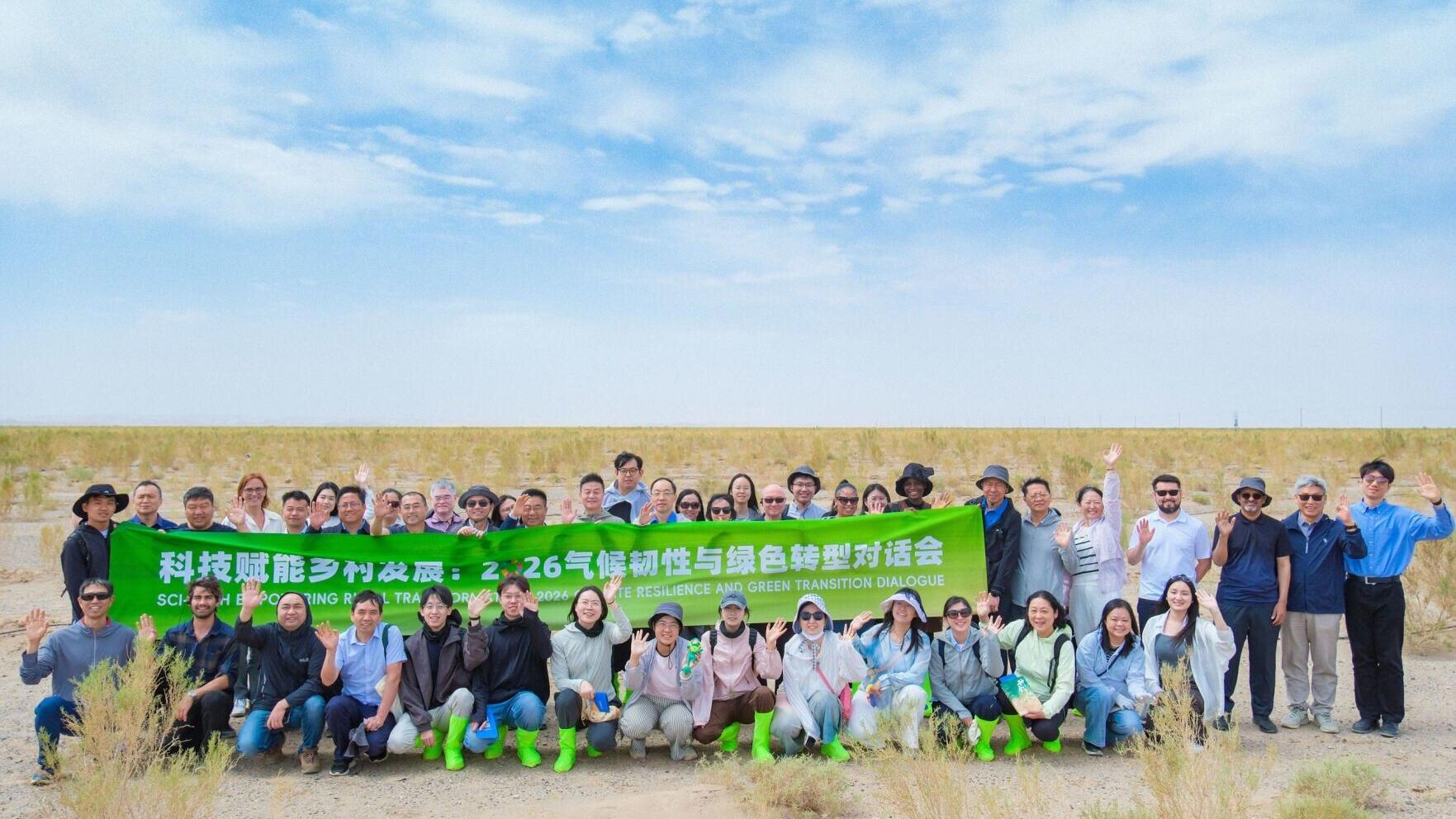 Some of the people who attended the Sci-Tech Empowering Rural Transformation: 2026 Climate Resilience and Green Transition Dialogue in person examine Haloxylon (saxaul)-Cistanche grafting and related desert-based industry development endeavors at an Ant...