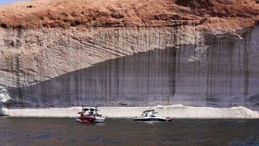 Boaters make their way past bathtub rings, showing the height of the water level in the past, on Lake Powell, Arizona on June 18, 2024