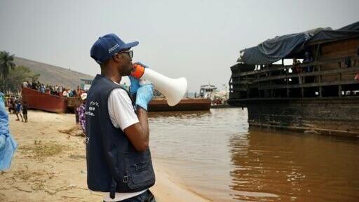Yves Matwa, an Ebola outbreak response worker, tells passengers on Congo river ferries to brace for checks before they can enter the DR Congo capital Kinshasa