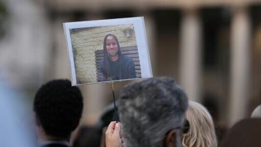 Supporters hold up a photo of Jason Arday during a a vigil for the late Cambridge professor in London's Trafalgar Square