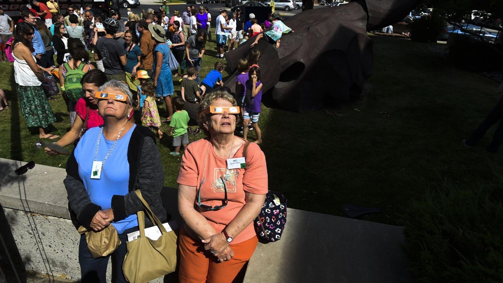 A few hundred people gather outside the Montana Historical Society Monday morning to view the solar eclipse.
