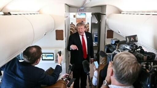 US President Donald Trump speaks to the press on board Air Force One, in the air en route to Michigan, on July 27, 2026