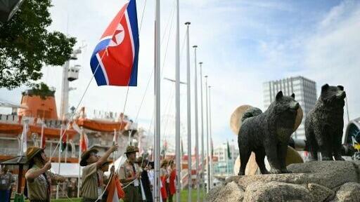 The North Korean flag is raised by scouts for the team welcome ceremony ahead of the 2026 Asian Games]