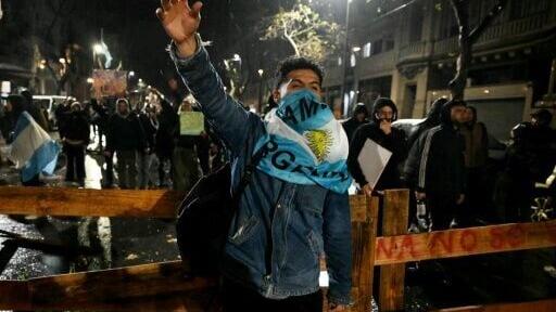 An Argentine demonstrator gestures in front of a barricade set up in Buenos Aires