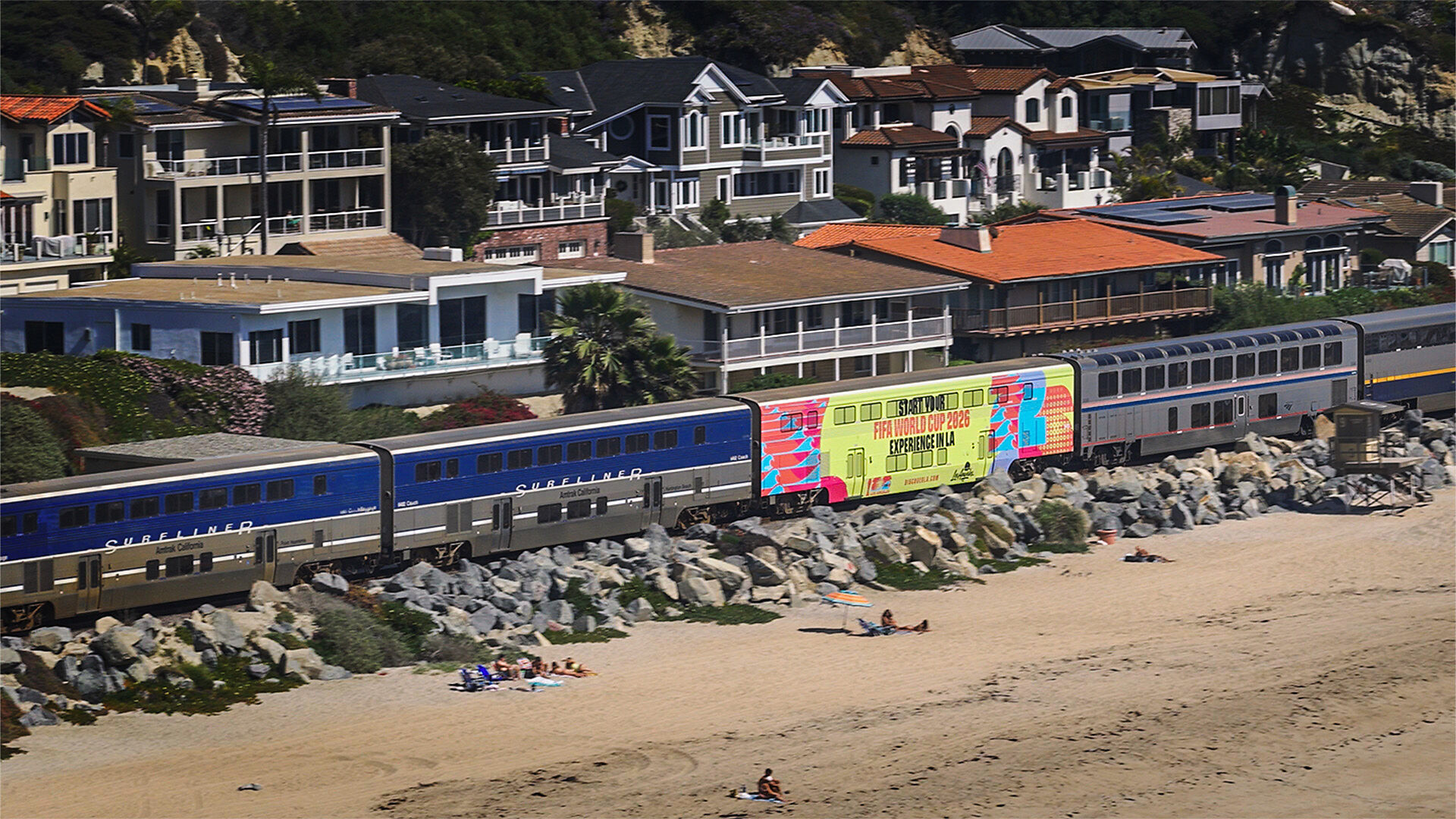Un tren Amtrak Pacific Surfliner viaja a lo largo de la costa sur de California con una envoltura especial de LA Tourism que promueve los partidos de fútbol del verano de 2026 en Los Ángeles.