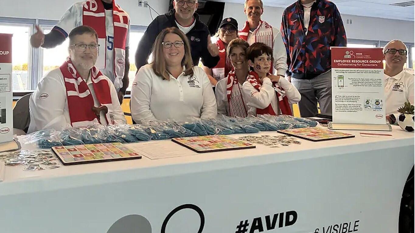 Members of Henkel’s Awareness of Visible and Invisible Disabilities (AVID) Employee Resource Group host a resource table featuring sign language and educational materials at the company’s Match and Mixer employee event.