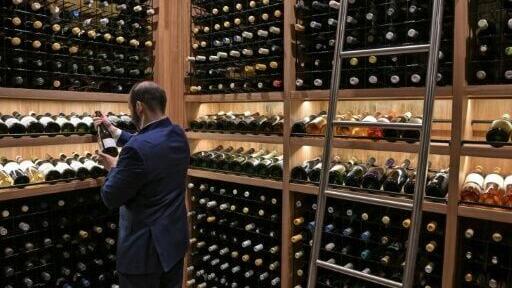 The evening begins with cocktails beneath a towering jabuticaba tree, native to Brazil, standing alongside a glass-enclosed wine cellar housing 5,000 bottles