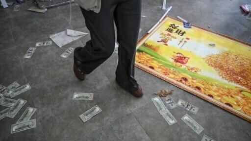 Counterfeit money was scattered on the floor of a shuttered scam centre in Cambodia