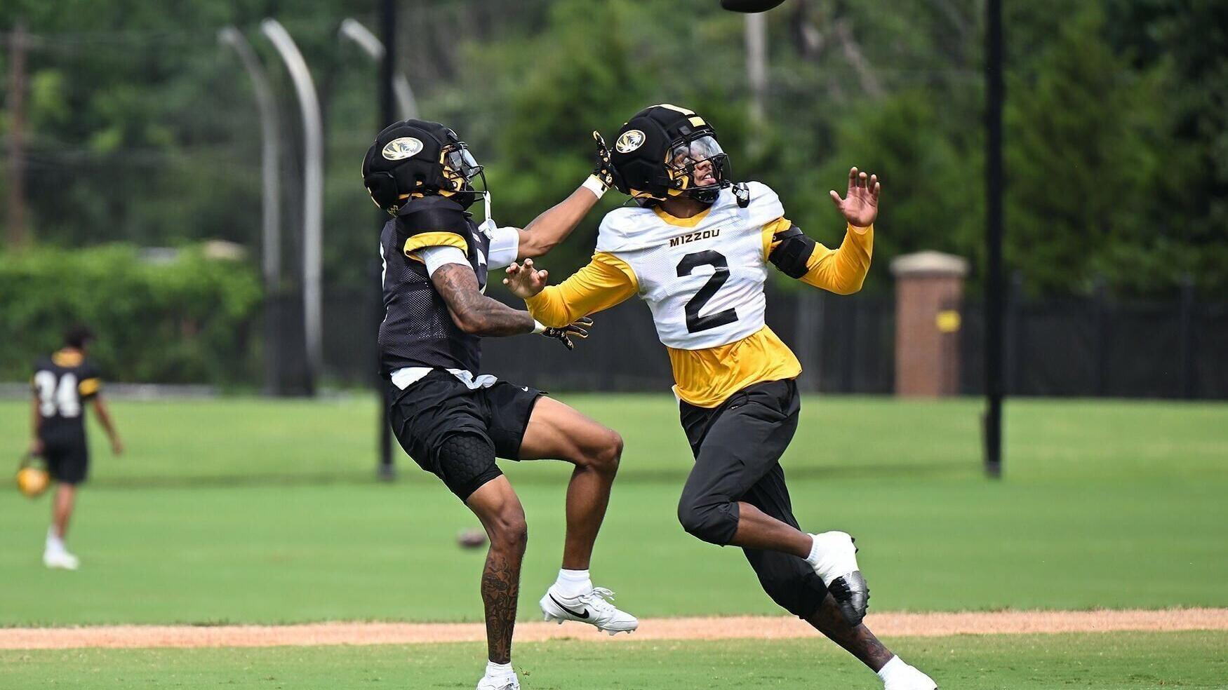 Mizzou wide out Caleb Goodie Sr. (2), left, tries to reach for the pass