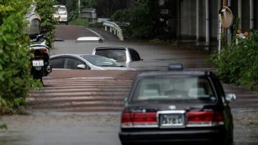 Partially submerged cars on a flooded road in Sakura, Chiba prefecture