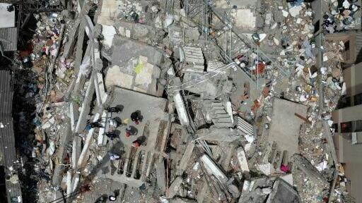 Rescuers search for survivors in the rubble of a collapsed building after an earthquake in Cali, Colombia