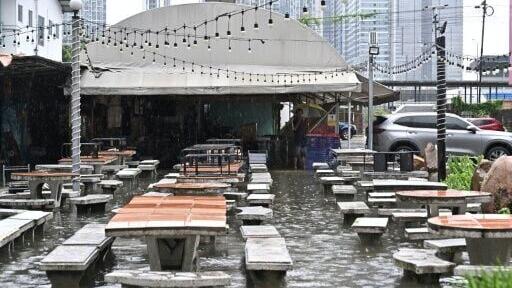 A man looks out from a flooded restaurant in Bangkok on September 26, 2026