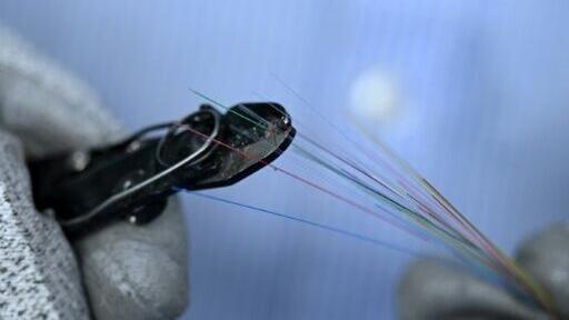 Technicians work around the clock to turn glass into hair-thin fibre-optic strands destined for data centres