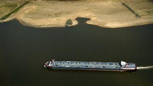 A vessel sails past receding riverbeds on the Rhine near Duesseldorf, western Germany, on Thursday