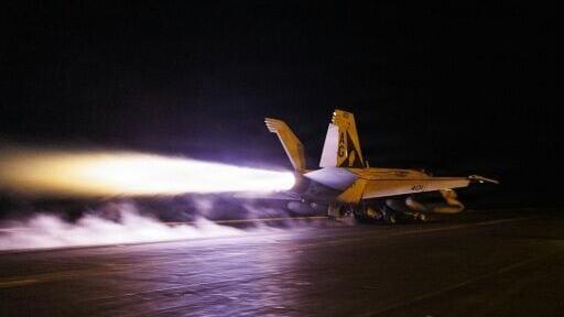 This US Navy handout photograph shows an F/A-18E Super Hornet launching from the flight deck of Nimitz-class aircraft carrier USS George H.W. Bush
