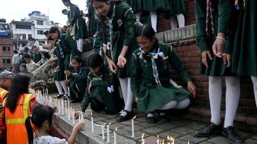 Nepali scouts and others light candles for flood victims during a vigil in Kathmandu on August 29, 2026