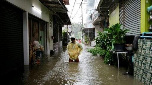 A person wades through floodwaters in the Bang Bua district of Bangkok on September 26, 2026.