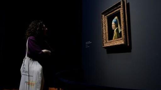 A women looks at the famous 'Girl with a pearl earing' at the Rijksmuseum in Amsterdam on February 6, 2023